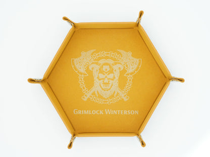 A hexagonal golden-yellow tray featuring a white printed Grimlock Winterson logo and name in the center, with small metal loops at each corner, shown on a plain white background.