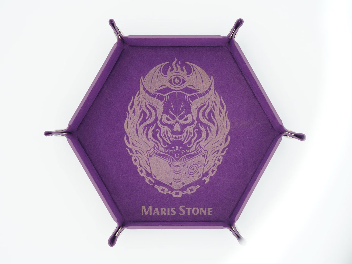 A purple hexagonal display stand with four metal legs and a central printed design of a skull wearing a crescent moon and eye helmet, with the text 'MARIS STONE' at the bottom.