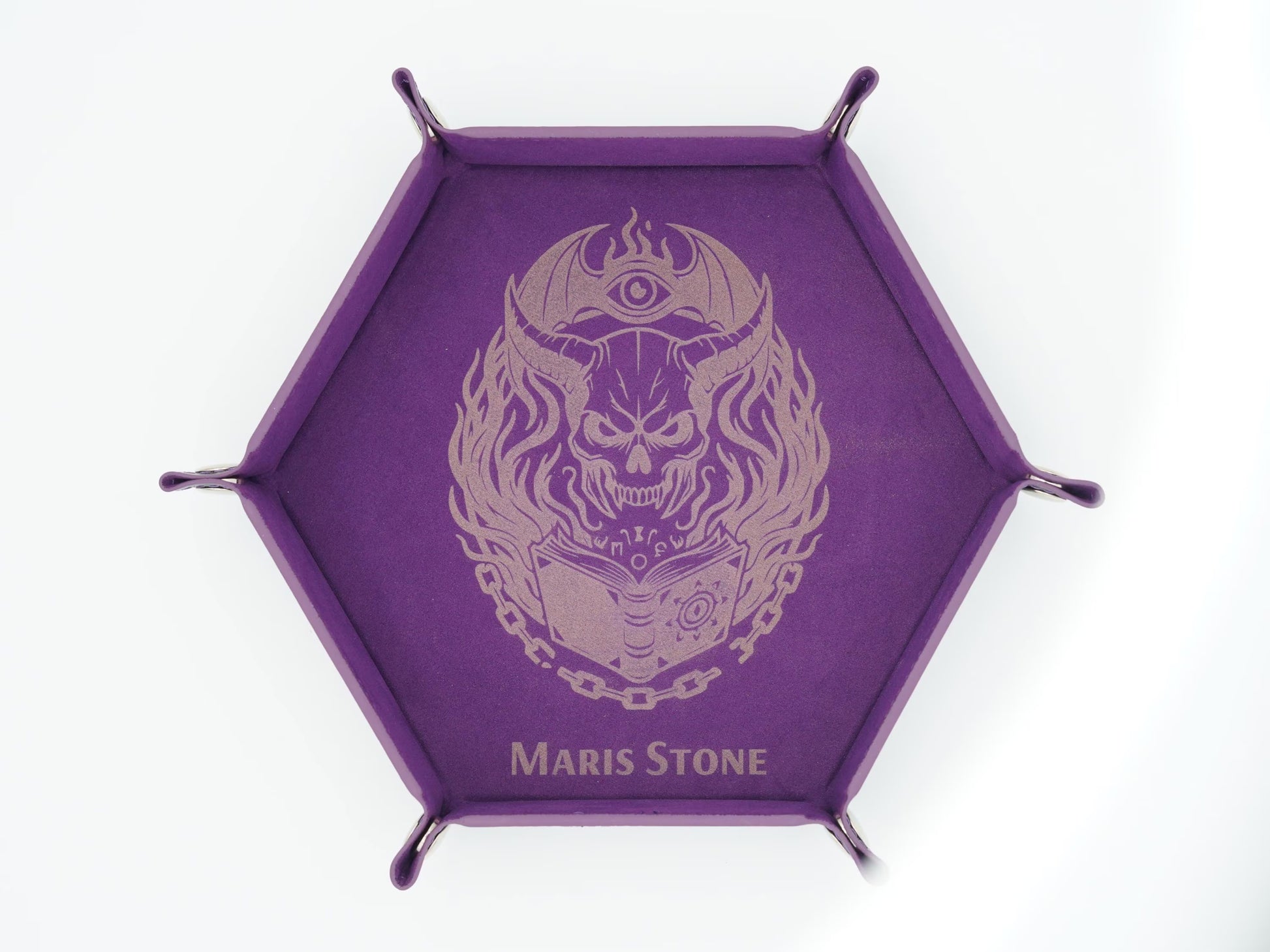 A purple hexagonal display stand with four metal legs and a central printed design of a skull wearing a crescent moon and eye helmet, with the text 'MARIS STONE' at the bottom.